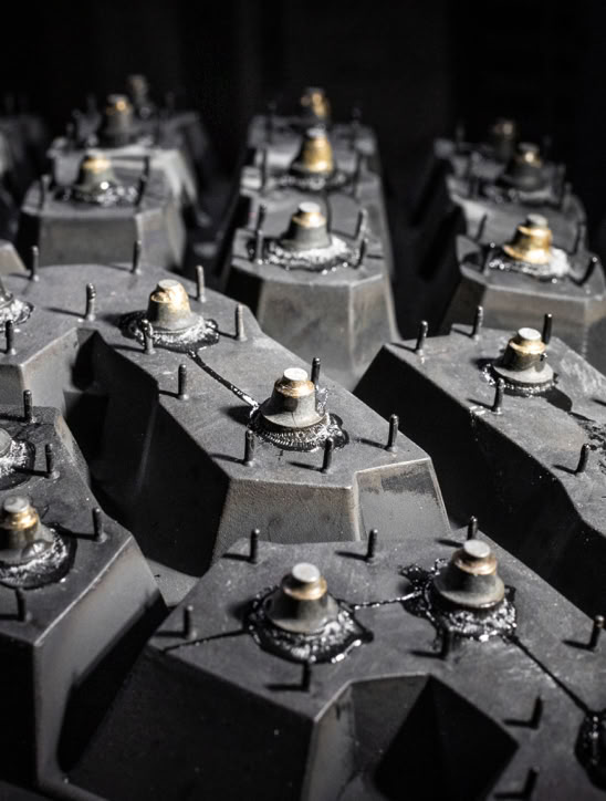 Close-up of a studded tire tread with metal studs protruding from the rubber surface.